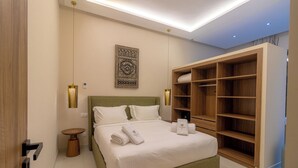 A modern bedroom with a large bed, a wooden wardrobe, and a small round table. - Villa Jamila Marrakech - Authentic luxury and heated private pool. (Marrakech)