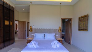 A neatly made bed with white linens and towels, a wooden wardrobe, and a decorative wall piece. - Villa Jamila Marrakech - Authentic luxury and heated private pool. (Marrakech)