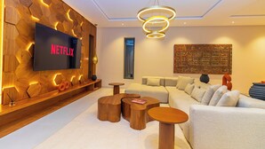 A modern living room with a Netflix TV, wooden decor, and a large abstract painting. - Villa Jamila Marrakech - Authentic luxury and heated private pool. (Marrakech)