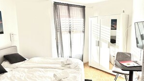 A hotel room with a bed, a desk, a chair, and a view of the outside. - Studio in the center, with pool and sauna, 400 mt from the ski lifts (Sankt Moritz)