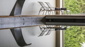 A room with a large window, a wooden table, and a metal chair. - Villa C Boutique Hotel (Azurara)