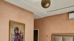 Una camera da letto con un letto grande, una testiera, un lampadario e un quadro appeso al muro.