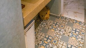 Un bagno con due lavandini, uno specchio e un pavimento decorato.