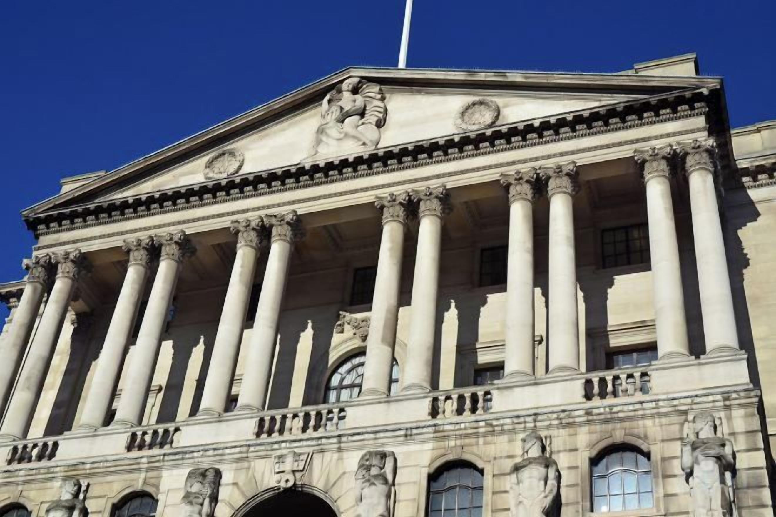 A classical building with a symmetrical facade, large columns, and statues.