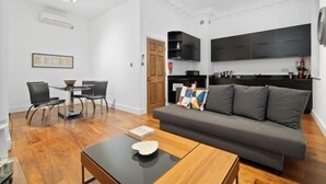 Un salon moderne comprenant un canapé, une table basse et un coin repas avec des chaises et une table.