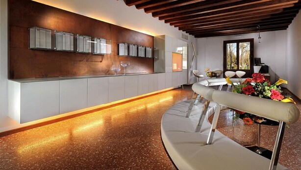 A modern kitchen with a wooden ceiling, a built-in wine rack, and a dining area with a white table and chairs. - Villa Veneta Ca' Sabbioni  (Mestre)