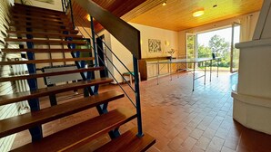 A wooden staircase with metal railings, a tiled floor, and a view of the outdoors through a large window. - Holiday Home 'Alpenblick' with Mountain View, Private Terrace and Wi-Fi (Rickenbach)