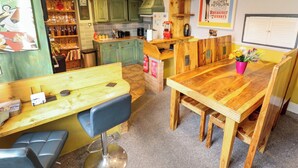 Una cocina rústica y acogedora, con armarios de madera, una mesa de comedor y un banco.