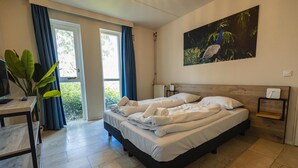 A bedroom with a bed, a desk, a chair, a window with curtains, a radiator, and a wall-mounted painting. - Detached Bungalow in Peaceful Setting (Ewijk)
