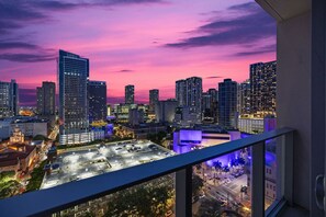 A cityscape at dusk with high-rise buildings, a parking lot, and a view from a balcony. - KING OF MIAMI - Center Downtown Bayside Pool/Gym (Miami)