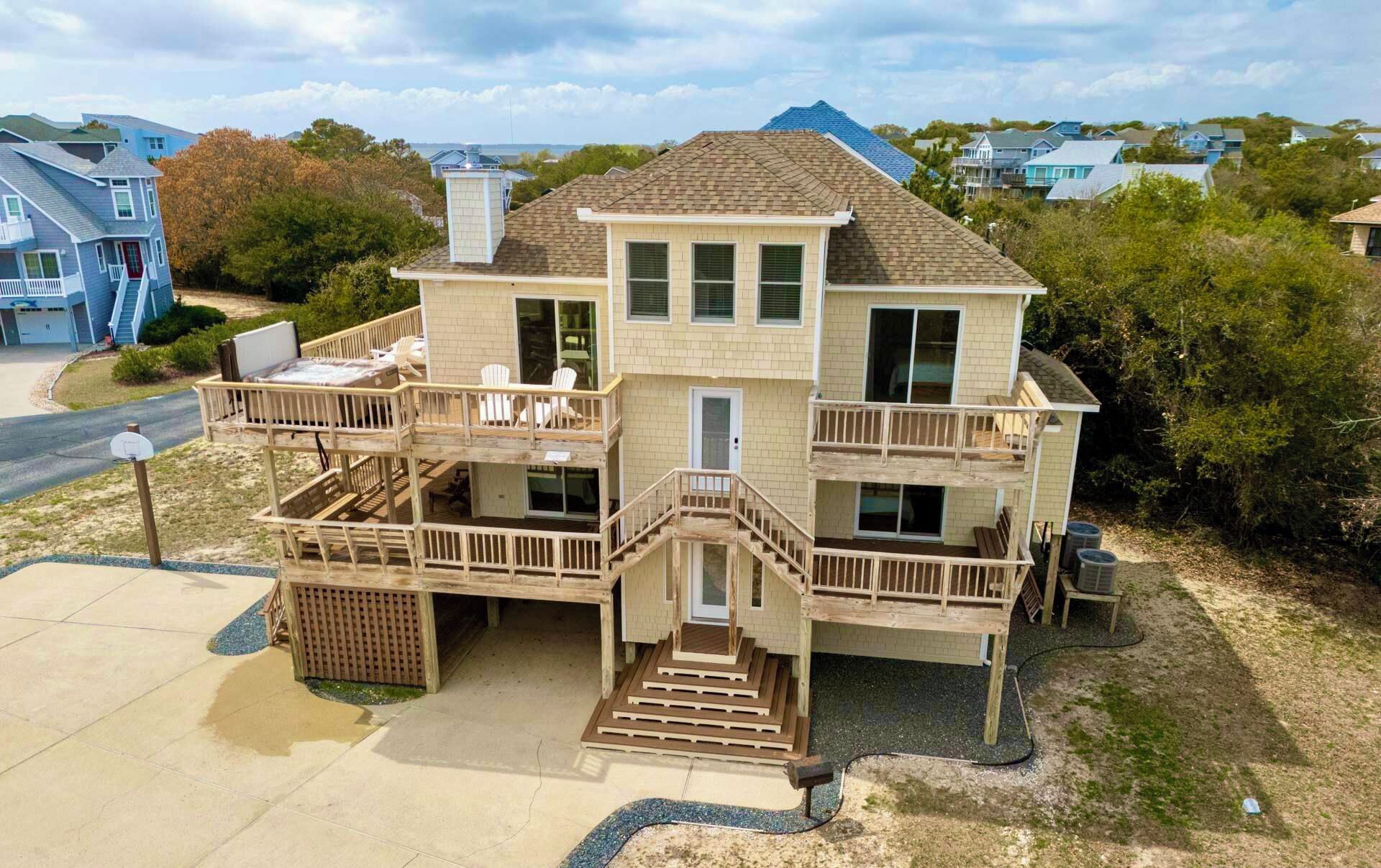 A two-story house with a balcony, a front porch, and a driveway.