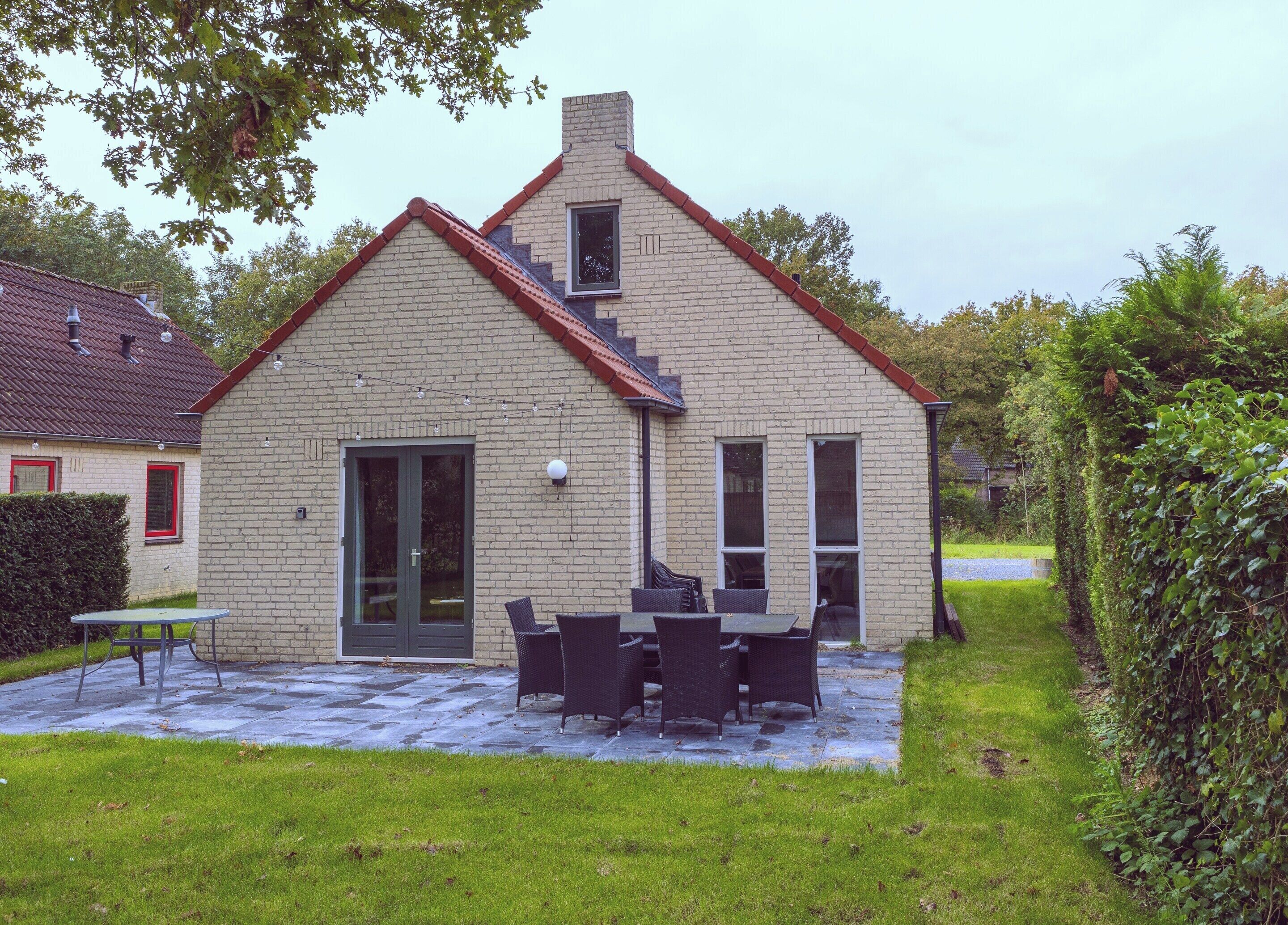 A two-story house with a brick exterior, a front door, and a small window.