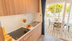 Una cucina moderna con mobili in legno, un piano di lavoro nero e un'area pranzo con tavolo e sedie.