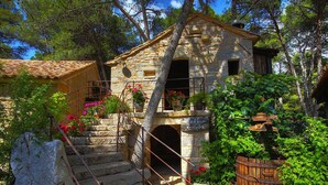 A rustic stone building with a stone staircase leading to a wooden door.