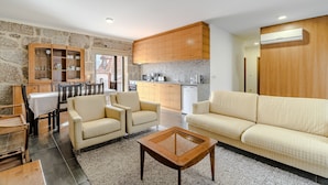 A modern living room with a sofa, chairs, a coffee table, and a dining area with a table and chairs. - Holiday Home 'Casa Feixa Gerês' with Mountain View, Wi-Fi & Air Conditioning (Gerês)
