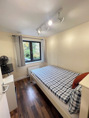 Tabla de planchar con plancha, internet y ropa de cama