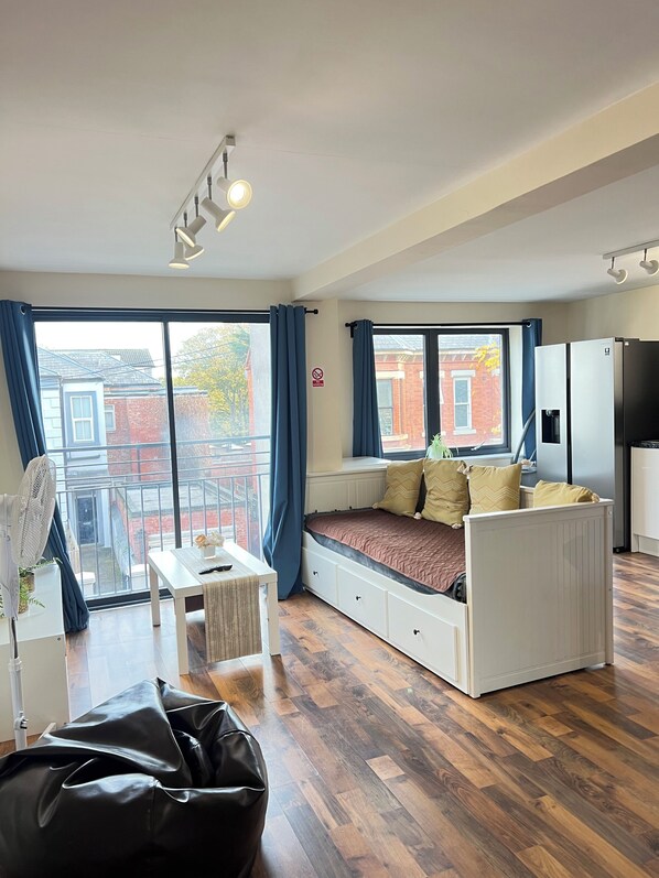 A modern apartment with a built-in bench seating area, a dining table, and a kitchenette.