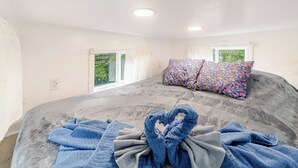 Una camera da letto con un letto grande, due cuscini decorati e un set di asciugamani.