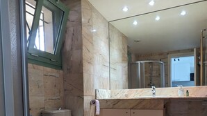 Een moderne badkamer met toilet, hygiëneschuimer en wastafel.