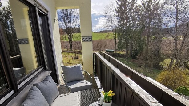 A balcony with a sofa, chairs, and a small table with a potted plant. - Vacation apartment "Fröhlich am Baderbichl" (Tutzing)