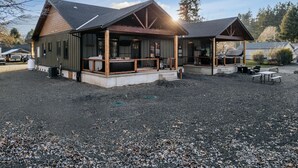 Eine Lodge mit zwei Hauptgebäuden, jeweils mit einer überdachten Veranda und Außenbestuhlung.