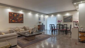 Un salon moderne avec un canapé, une table basse et un coin repas.