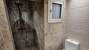 A bathroom with a shower, toilet, and a window. - Charming 1-bedroom apartment in the heart of welcoming Agia Napa with AC (Ayia Napa)