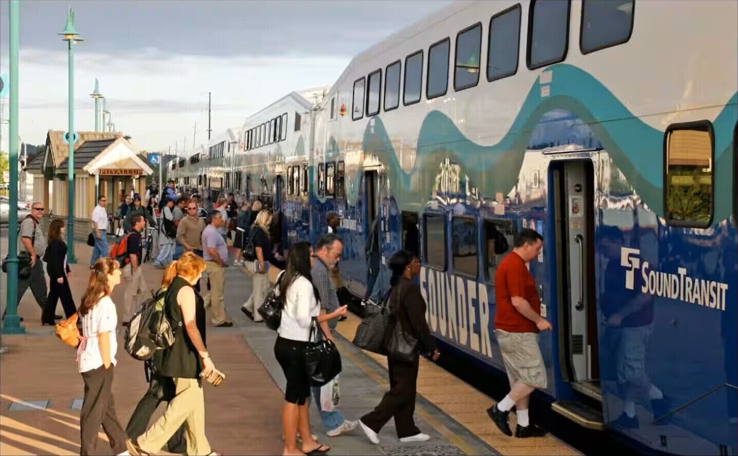 Et togspor med et tog mærket "SoundTransit", og passagerer stiger om bord.