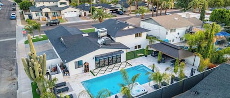 Un quartier résidentiel doté d’une piscine, de maisons et de palmiers.