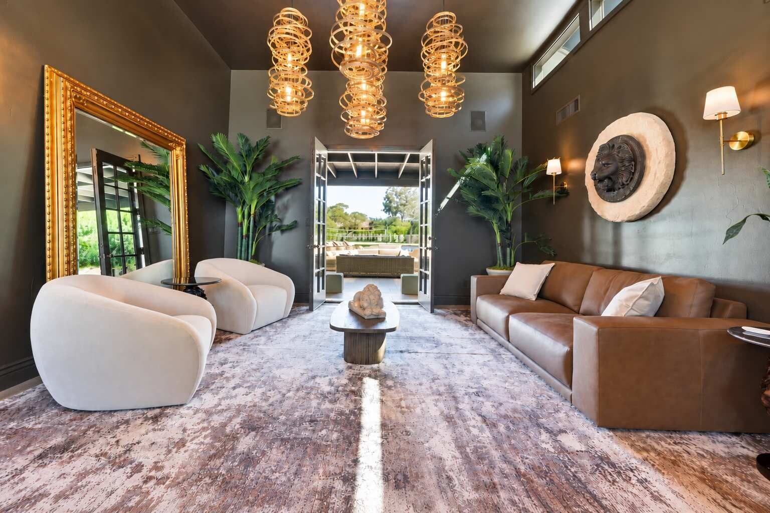 Un salon moderne avec un grand miroir, deux canapés, une table basse et une cheminée en pierre.
