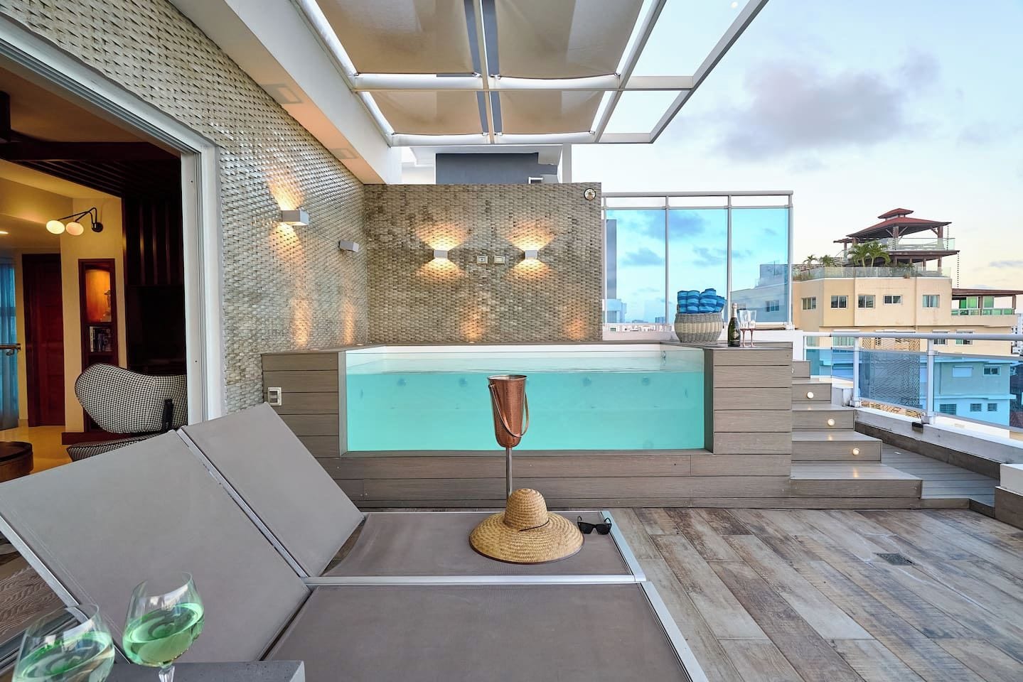 Une terrasse sur le toit équipée d’un jacuzzi, d’un espace salon et offrant une vue sur le paysage urbain.