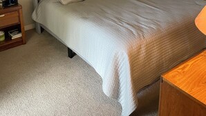 Ein Schlafzimmer mit Bett, Nachttischen, Deckenventilator und Kleiderschrank.