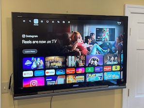 Pantalla de televisión mostrando varios servicios de transmisión y un botón de 'Más información'.