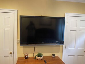 Un televisor de pantalla plana sujeto a la pared entre dos puertas blancas.