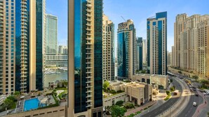 A high-rise residential building with multiple balconies, a swimming pool, and a view of a marina. - Cozy 3 Bedroom with walking access to JBR Beach (Jumeirah Beach Residence (JBR))