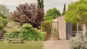A garden with a bench, a pergola, and a building with a window. - Villa Glicini - Delightful Cottage With Pool (Ostra)