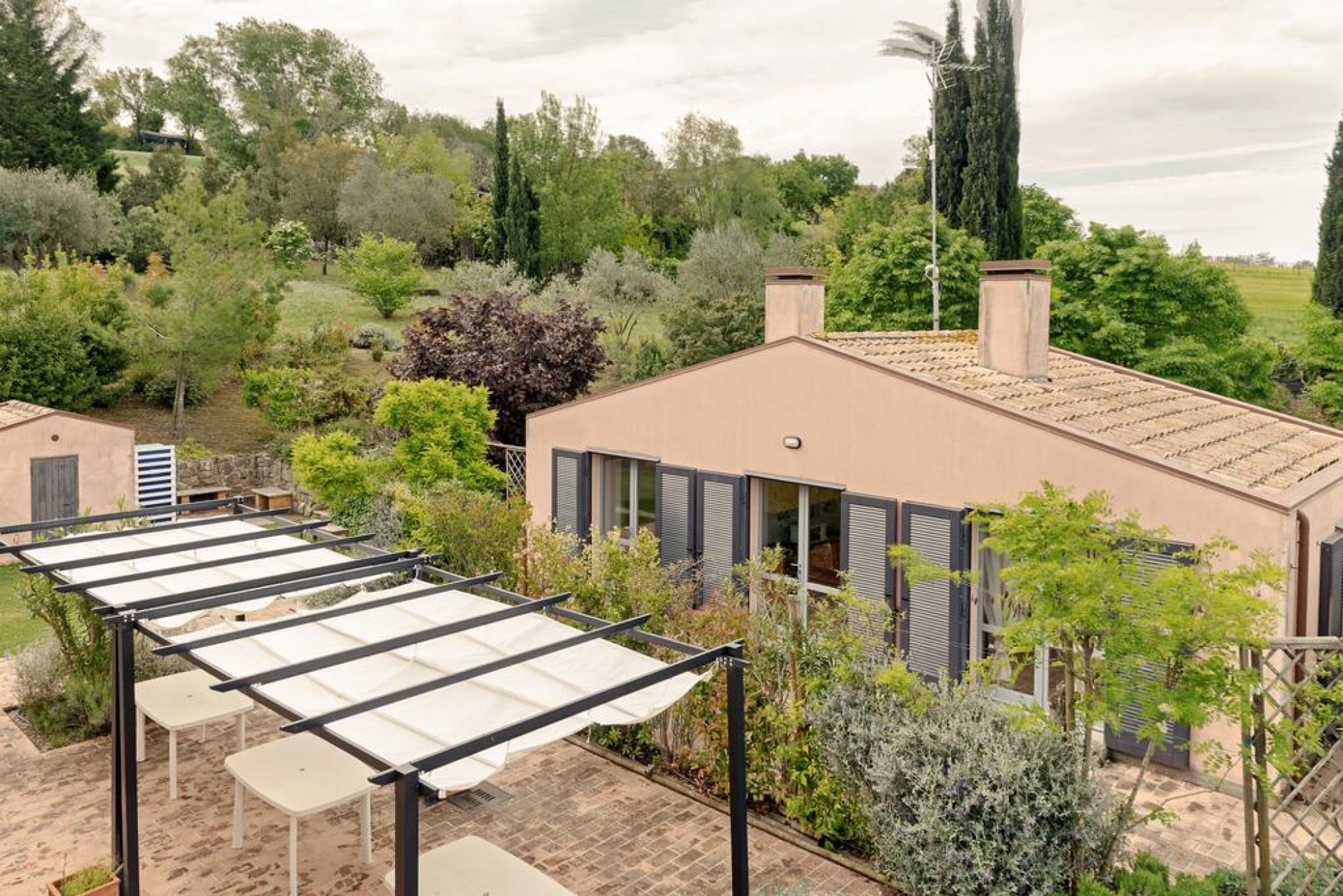 Une maison avec une véranda, un espace salon extérieur et un jardin.