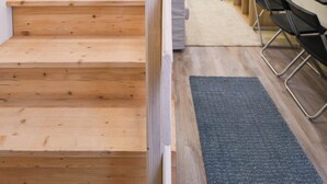 Eine Treppe führt zu einem Raum mit Schreibtisch, Stuhl und Pflanze.