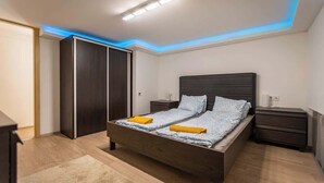 Un dormitorio moderno con una cama grande, mesitas de noche y un armario.