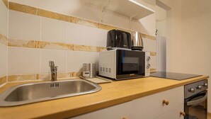 A kitchen with a sink, a microwave, a coffee maker, and a stove. - Klauzal  · 2 bedroom downtown flat in Budapest, Lisa (Budapest)