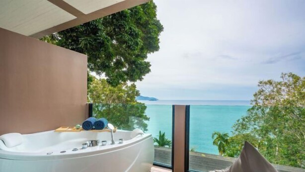 A modern bathroom with a large bathtub, a view of the ocean, and a balcony with a view. - Anona Sunset Boutique (Phuket)