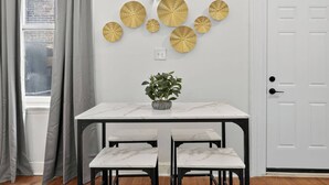 A dining area with a white marble table, two matching chairs, and a potted plant. - 1/1 Center City Sleeps 6 Fast Wifi (Philadelphia)