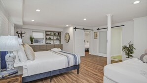 A modern bedroom with a large bed, bedside tables, a desk, and a wardrobe. - Forest Lake Retreat | Backyard Sanctuary & Hot Tub (Columbia)