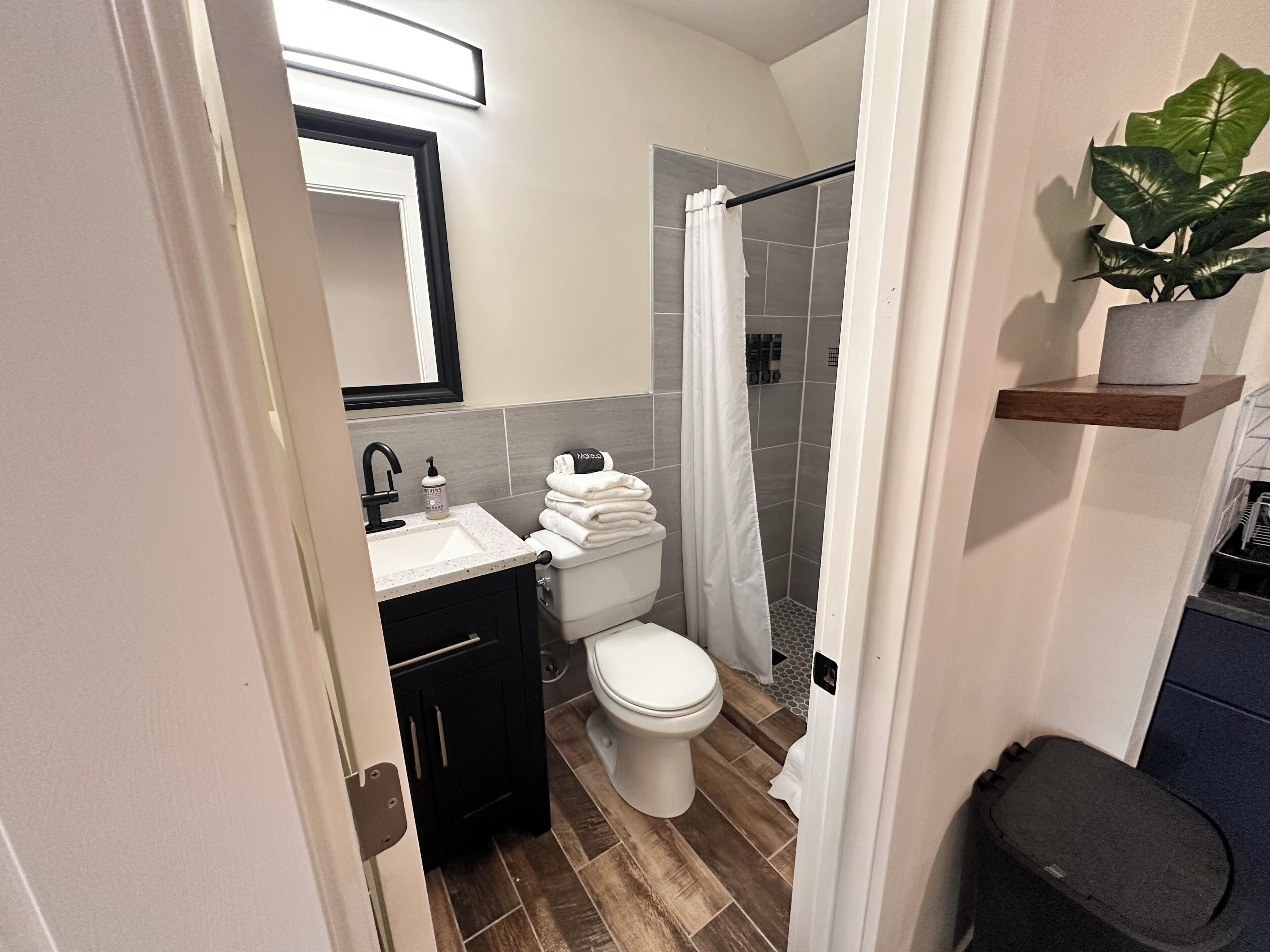 Une salle de bain moderne équipée d’un lavabo, de toilettes et d’une zone douche.