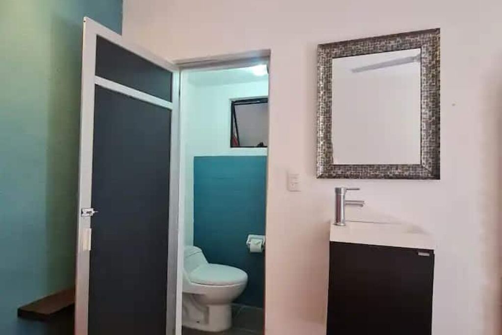 Ein Badezimmer mit Toilette, Waschbecken und einem Spiegel an der Wand.