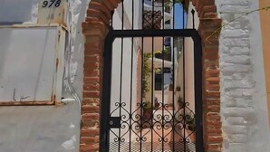A gated entrance with a brick archway and a metal gate.
