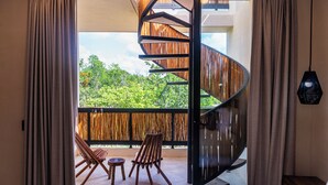 Un dormitorio con una escalera de caracol que lleva a un balcón.