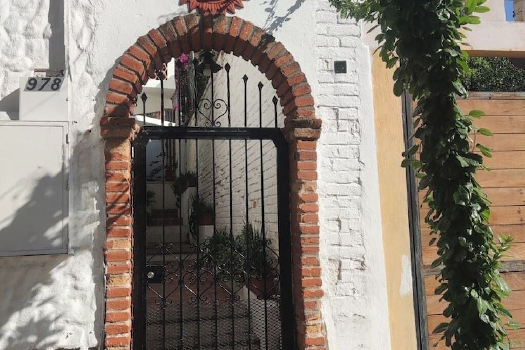 Un edificio de ladrillo blanco con una reja negra de hierro y un letrero con el número 978.