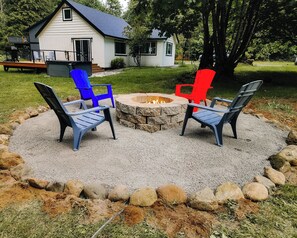 A fire pit area with chairs, a house in the background, and a grassy yard. - The Brightwood Hilton house, hot tub, 3 bedrooms. Sleeps 8 (Mount Hood Village)