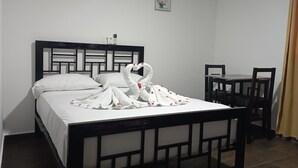 Une chambre d’hôtel avec un lit, un bureau et deux chaises.